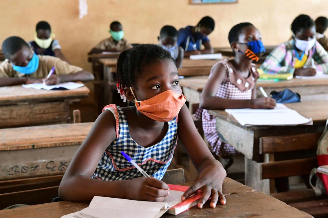 Students wearing face masks attend class in a school