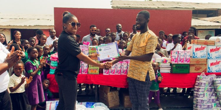 Country Manager of Silverbird Cinemas Ghana, Funmi Onuma presenting items to Edward Honest Polley, Administrator of Savior Children Foundation