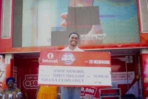 Andy Annobil holds the GH¢30,000 weekly prize cheque at the Telecel More Money promo presentation ceremony in Takoradi.