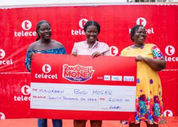 Maureen Bus-Moses (middle), a 2Moorch Money promo weekly prize winner, receives the cheque of GH₵20,000 with her mother and sister at the Takoradi Market Circle